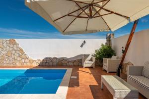 a patio with an umbrella and a swimming pool at Villa Gle Apt 1 in Quartu SantʼElena