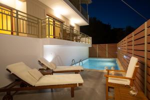 a patio with two chairs and a swimming pool at Nikolas Guest House Villa in Nikiana