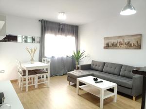 sala de estar con sofá y mesa en Apartamentos Coralba - El Escondite de la Bahía, en San Fernando