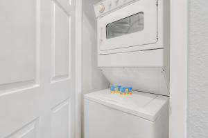 een witte keuken met een witte oven en 2 speelgoedklokken bij West Rockford Condo 140 in Branson