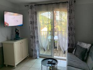 a living room with a couch and a sliding glass door at Duplex village vacances Grospierres in Grospierres