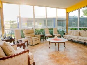 a living room with couches and tables and windows at Casa Bakab By Rotamundos in Chablekal