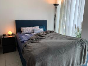 Una cama con una manta en una habitación con ventana en Exklusive Wohlfühloase by Rabe - Parkplatz & free Netflix & Coffee-Bar en Karlsruhe