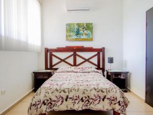 um quarto com uma cama e duas mesas de cabeceira em Casa Bakab By Rotamundos em Chablekal