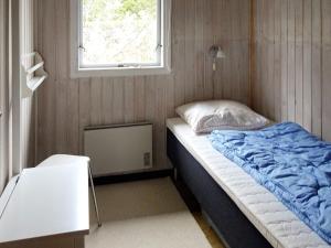 um pequeno quarto com uma cama e uma janela em Three-Bedroom Holiday home in Hals 38 em Hals
