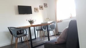 a living room with a table with chairs and a tv at Ferienwohnungen Busch`s Gästehaus in Rust
