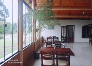a group of tables and chairs in a room with windows at RECANTO CANTAGALO Hotel in Cantagalo