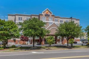 an office building with trees in front of a street at Comfort Inn & Suites Virginia Beach-Norfolk Airport in Virginia Beach