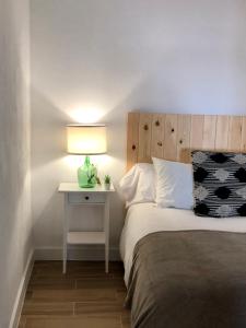1 dormitorio con 1 cama y 1 mesa con lámpara en Damajuana, en Níjar