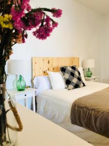 1 dormitorio con 2 camas con flores en la pared en Damajuana, en Níjar