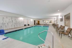 una piscina en un hotel con sillas y mesas en Sleep Inn, en Clovis