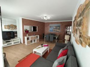 ein Wohnzimmer mit einem Sofa und einem Tisch in der Unterkunft Apartamento S. João da Foz in Porto