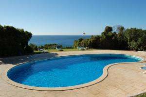 a swimming pool with a view of the ocean at Ocean facing at Senhora da Rocha in Porches