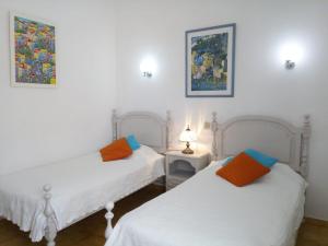 two beds in a room with white walls at Ocean facing at Senhora da Rocha in Porches +48 photos