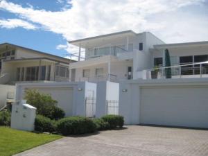 a large white house with a garage at Ultimate Beach House views peace and quiet in Anna Bay