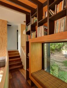 a home library with wooden shelves and a window at Blackpool House in Oneroa
