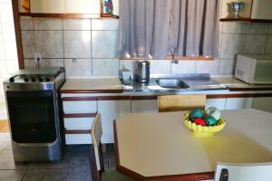 a kitchen with a table with a bowl of fruit on it at Apartamento Beira Mar in Pontal do Paraná
