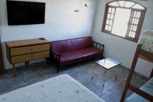 sala de estar con sofá rojo y mesa en Apartamento Beira Mar en Pontal do Paraná