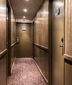 a hallway with doors and a carpeted corridor at Hôtel Elysées Flaubert in Paris