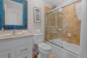 a bathroom with a toilet and a shower and a sink at The Tequila Sunrise at Lazy Way in Fort Myers Beach