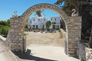 an archway with swans on it in front of a resort at Kiki's apartment veranda dream in Chrissi Akti