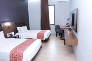 Postel nebo postele na pokoji v ubytování Grand Kangen Hotel Urip Sumoharjo