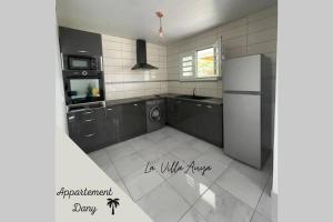 eine Küche mit einem Kühlschrank, einer Waschmaschine und einem Trockner in der Unterkunft Villa Auya entre mer et montagne in Le Carbet