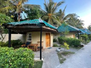 mały dom z niebieskim dachem i werandą w obiekcie Victory Seaside Home w mieście Wyspa Bantayan