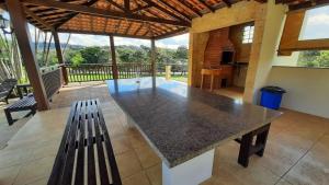einem großen Tisch in einem Zimmer mit einer Bank in der Unterkunft Pousada Recanto Por do Sol in Morungaba