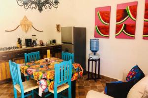 La cuisine est équipée d'une table avec des chaises bleues et d'un réfrigérateur. dans l'établissement Villa Puerta Azul at La Casa de Frida, à Loreto