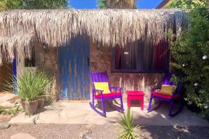 une maison avec deux chaises et un toit de chaume dans l'établissement Villa Puerta Azul at La Casa de Frida, à Loreto