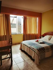 a bedroom with a bed and a desk and a window at Hotel el León de Oro in Jaén