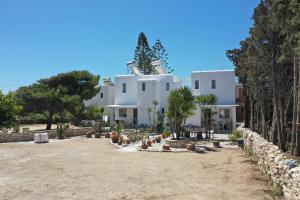 a large white building with trees in front of it at Kiki's dream apartment balcony with sea views in Chrissi Akti