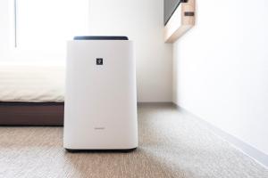 a white refrigerator sitting in a room next to a bed at Super Hotel Nagoya Shinkansenguchi in Nagoya