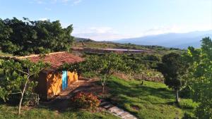 une maison dans un champ avec des montagnes en arrière-plan dans l'établissement Serrania del Viento, à Barichara