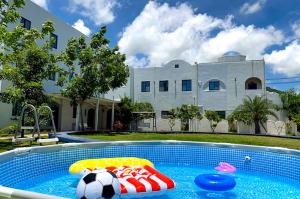 Una casa con una piscina con una pelota de fútbol. en Cest La Vie Villa, en Hengchun
