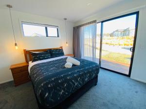 a bedroom with a large bed and a large window at Flat White in Lake Tekapo