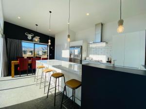 a kitchen with a counter and bar stools at Flat White in Lake Tekapo