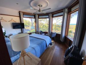 新月岬The Pool House - Crescent Head - stunning ocean views, pet friendly的一间卧室配有一张床、一盏灯和窗户