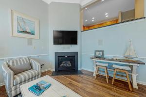 Ocean ViewにあるBayside Bethany Lakes - 38337 N Mill Ln 118の暖炉とテレビのあるリビングルーム