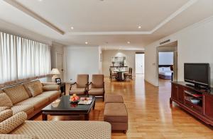 a living room with a couch and a television at Riverine Place Hotel and Residence in Nonthaburi