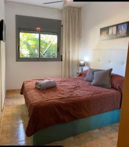1 dormitorio con 1 cama con edredón rojo y ventana en Ground Floor With Private Terrace And Community Area, Platanera, en Calafell