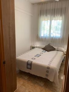 Un dormitorio con una cama blanca con una ventana. en Ground Floor With Private Terrace And Community Area, Platanera, en Calafell 12 fotos más