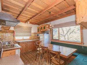 a kitchen with wooden cabinets and a table and chairs at The Nook 1 of5 The Nook in Jindabyne