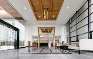 a lobby of a building with large windows at Riverine Place Hotel and Residence in Nonthaburi