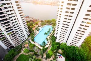 uma vista aérea de uma piscina entre dois edifícios altos em Riverine Place Hotel and Residence em Nonthaburi