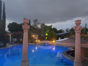 - une grande piscine avec piliers dans la cour dans l'établissement Gran Hotel Hacienda De La Noria, à Aguascalientes