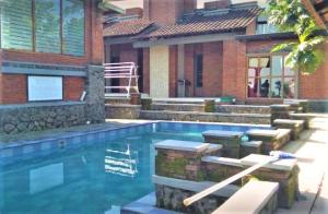a swimming pool in front of a house at Villa Mediana in Mojokerto