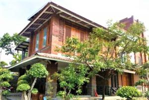 a brick house with trees in front of it at Villa Mediana in Mojokerto