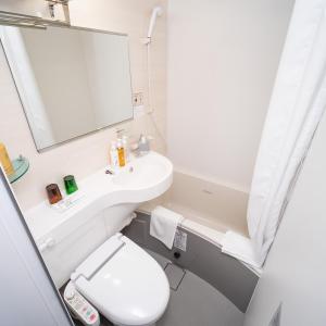a bathroom with a toilet and a sink and a mirror at Super Hotel Nagoya Shinkansenguchi in Nagoya